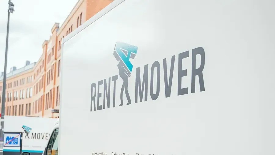 Flyttpersonal från Rent A Mover bär flyttkartonger vid flyttbilen under en bohagsflytt i Stockholm